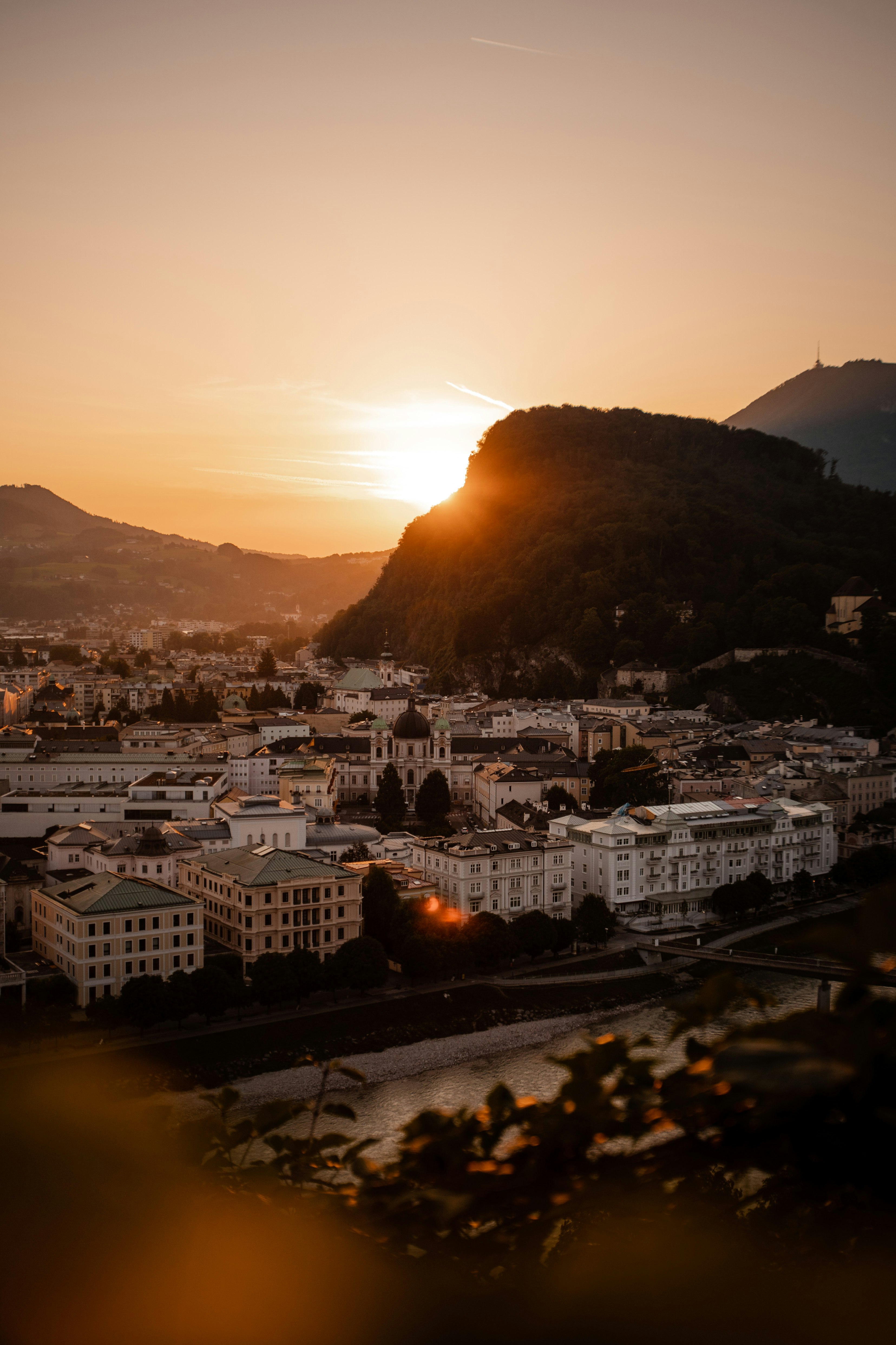 city buildings near mountain during sunset